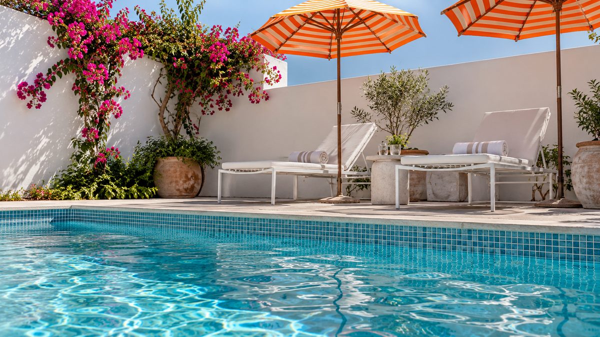 Blue swimming pool with orange-striped umbrellas