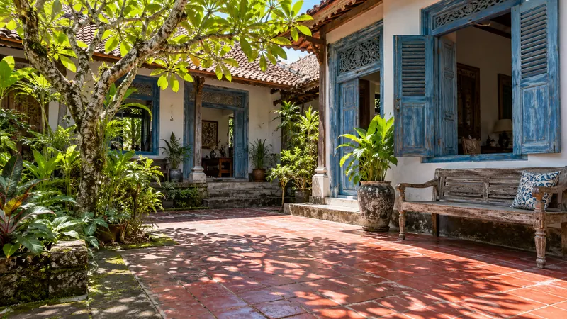 Sunlit guesthouse courtyard with blue shutters